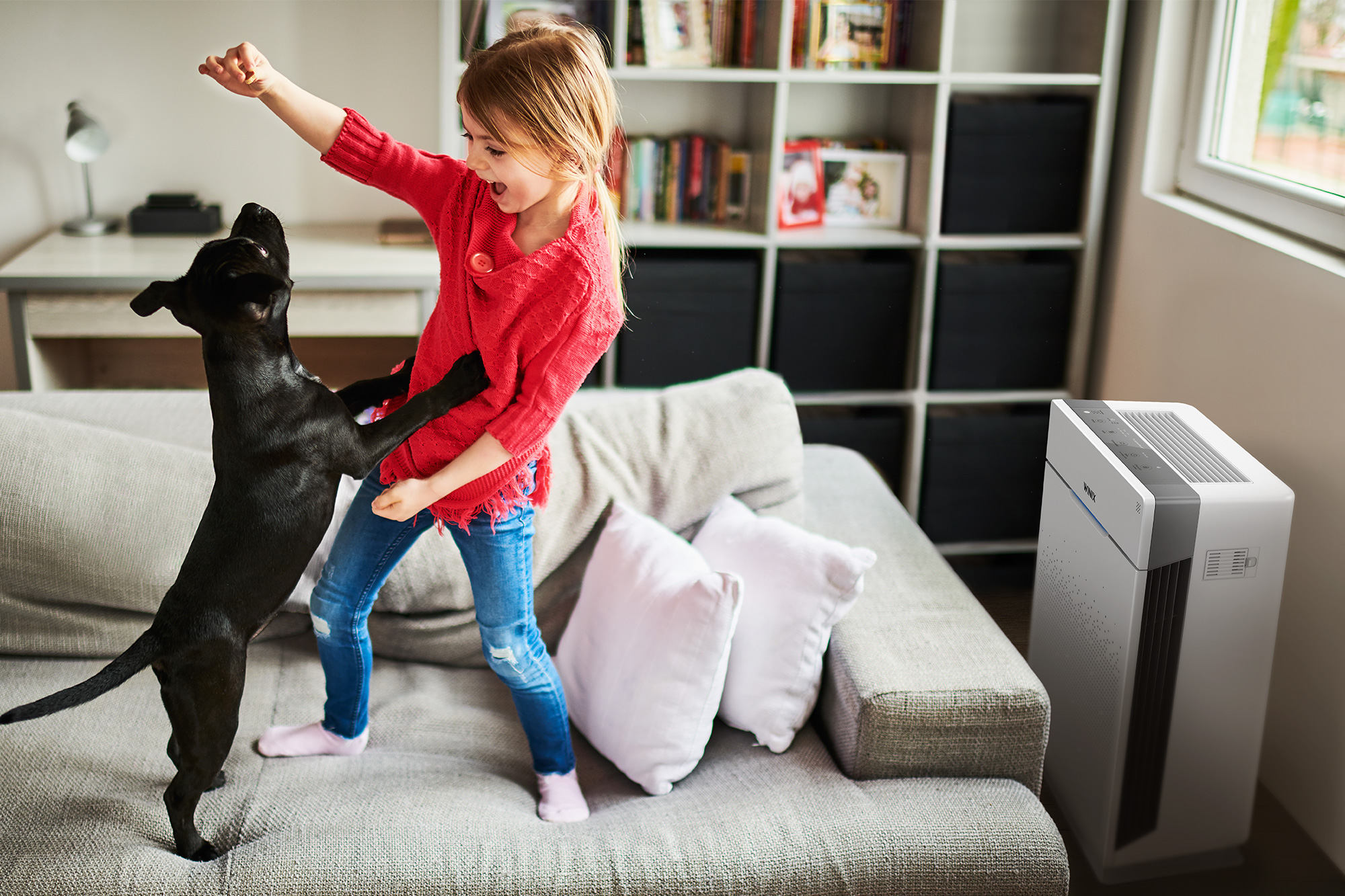 HR900 Ultimate Pet Air Purifier on floor next to young child playing with a dog