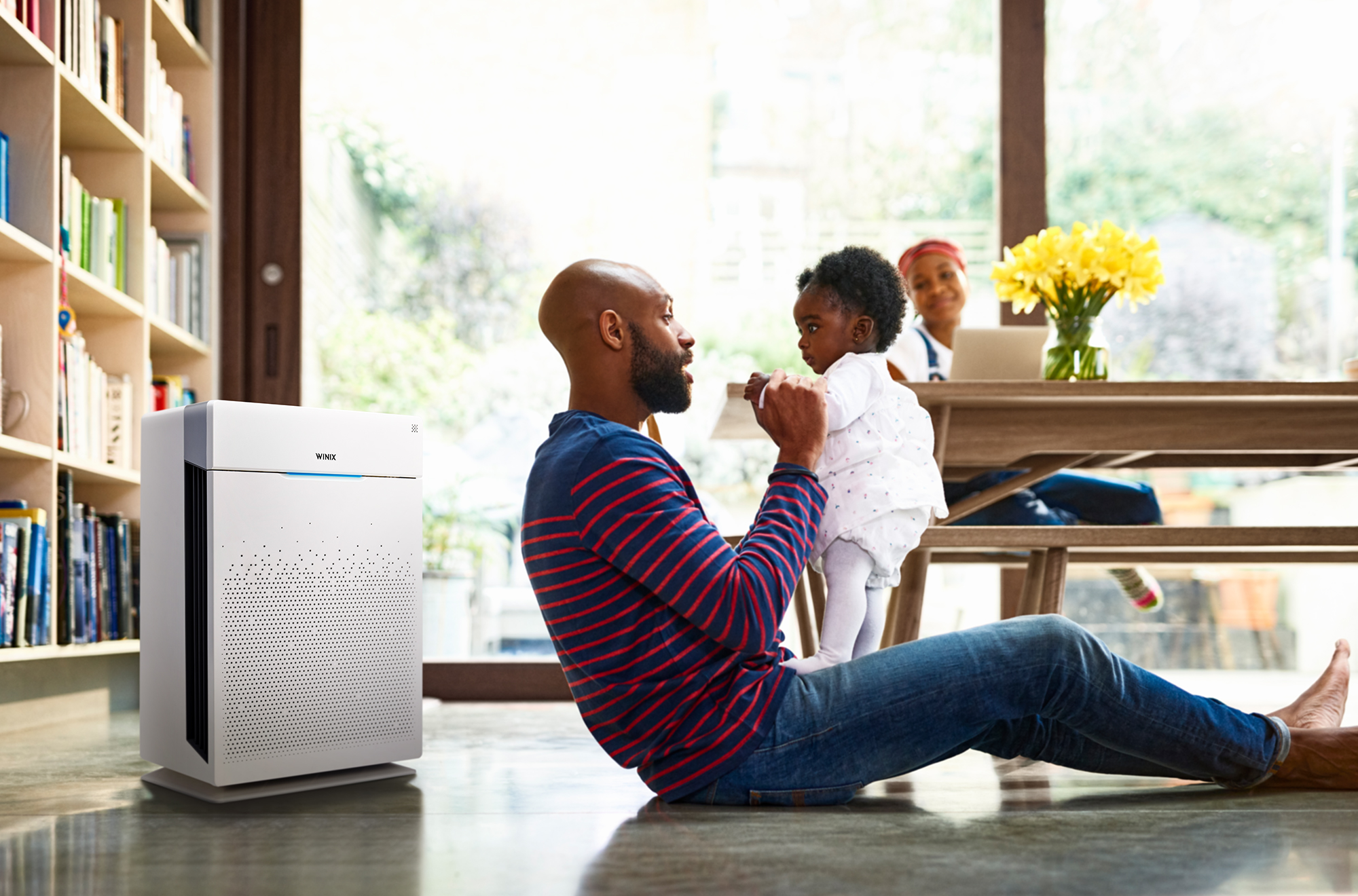 HR900 air purifier on floor next to adult and child