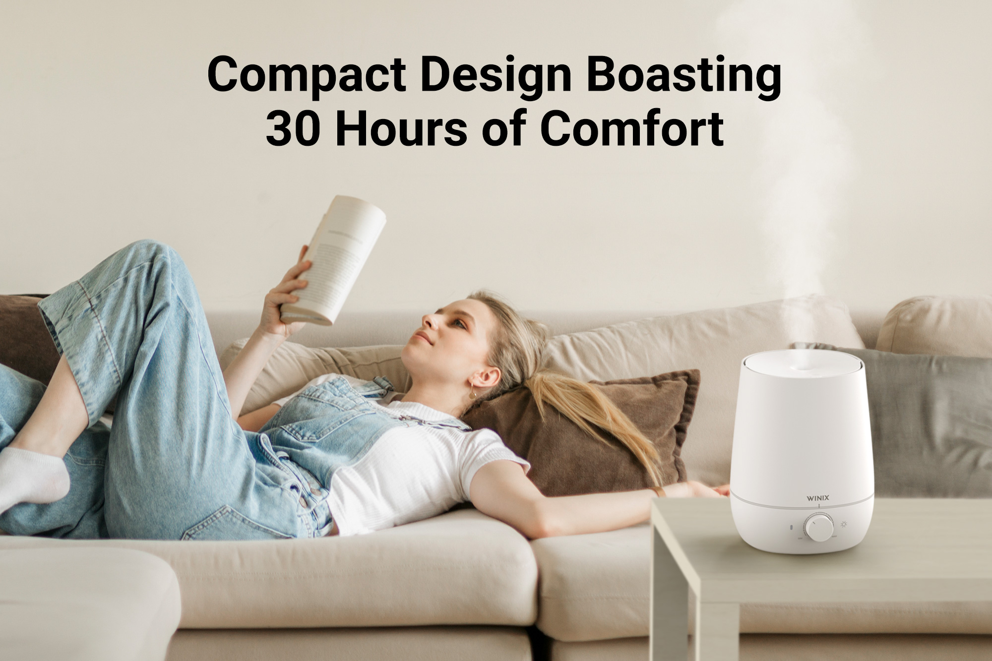 L60 Humidifier on coffee table next to woman relaxing on a couch and text saying compact design boasting 30 hours of comfort