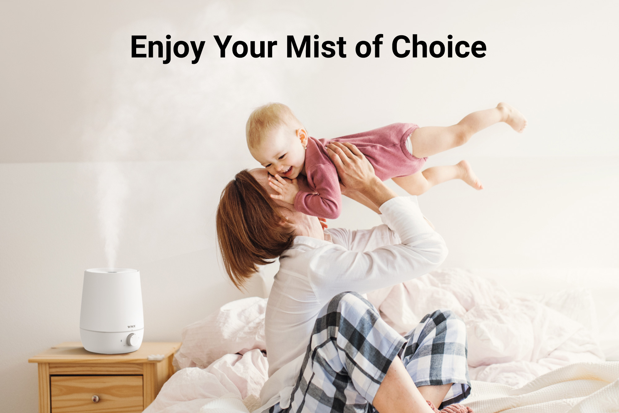 L60 Humidifier on nightstand next to woman and smiling baby and text saying Enjoy your Mist of Choice