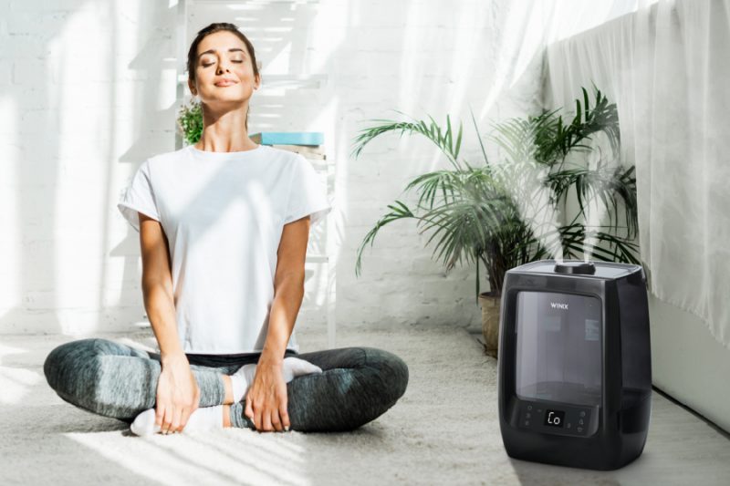 Woman in yoga pose enjoying the scent of Pre-Soaked Aroma Pads from L200 Humidifier